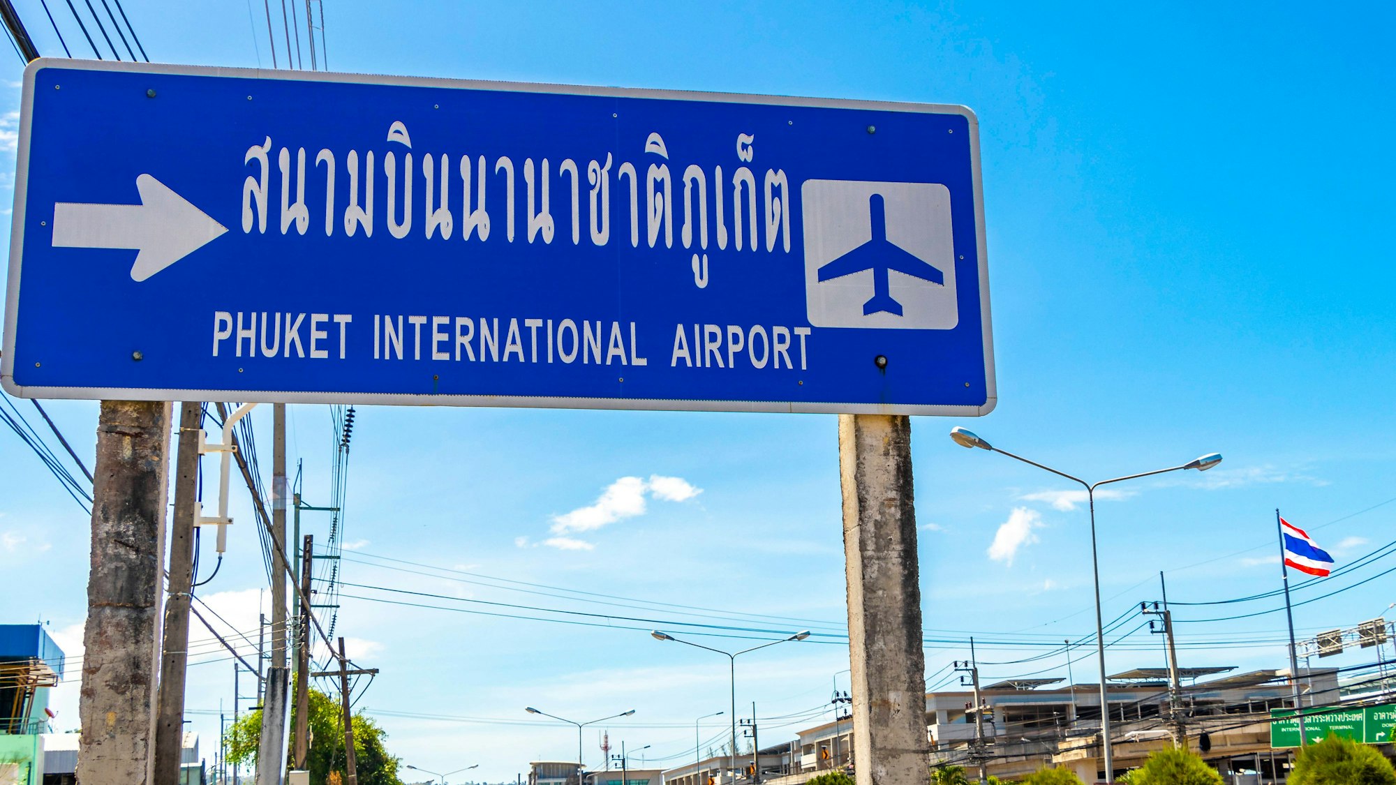 Schild zum Flughafen Phuket unter blauem Himmel