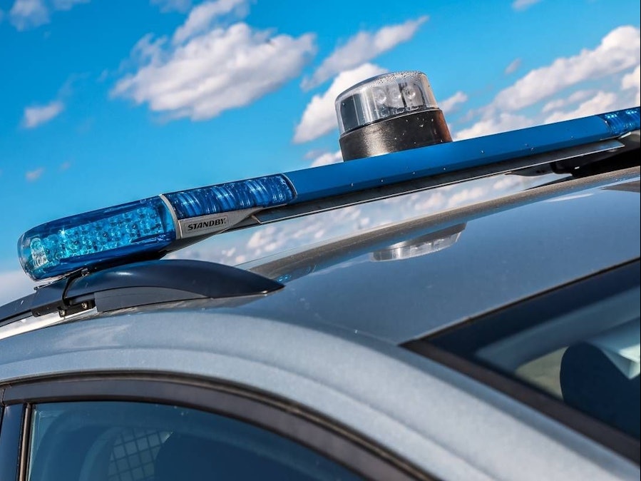 Polizeiauto mit Blaulicht vor blauem Himmel
