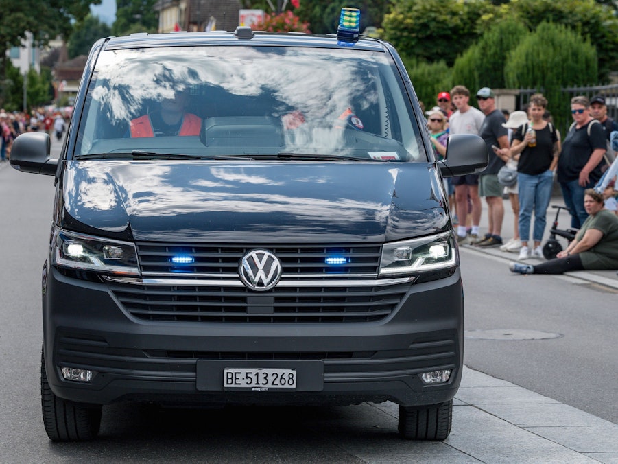Polizeiauto mit Blaulicht und Menschen
