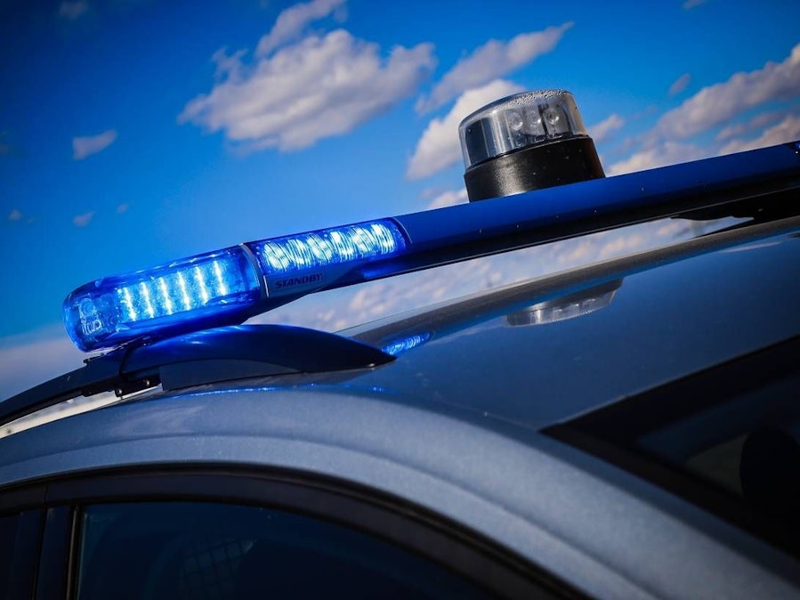 Polizeiwagen mit Blaulicht unter blauem Himmel