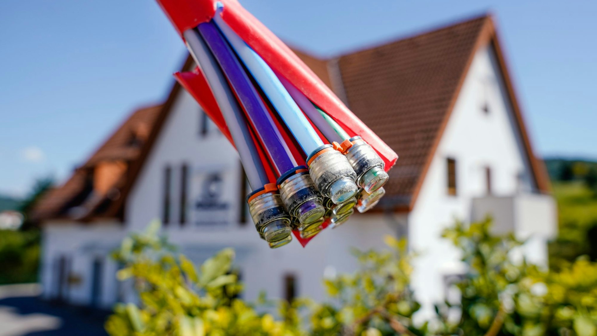 Bündel mit Umhüllungen für Glasfaserkabel vor einem Wohnhaus