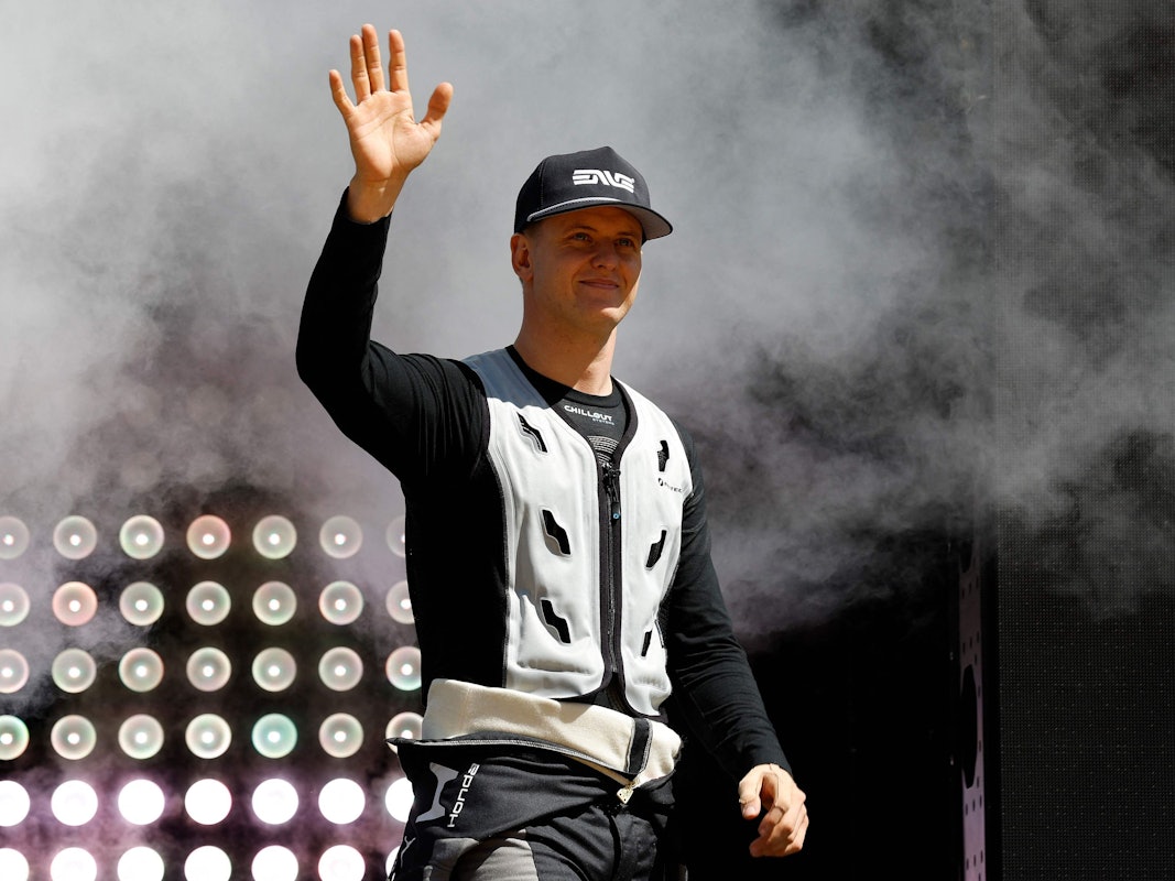 Mick Schumacher winkt auf der Bühne.