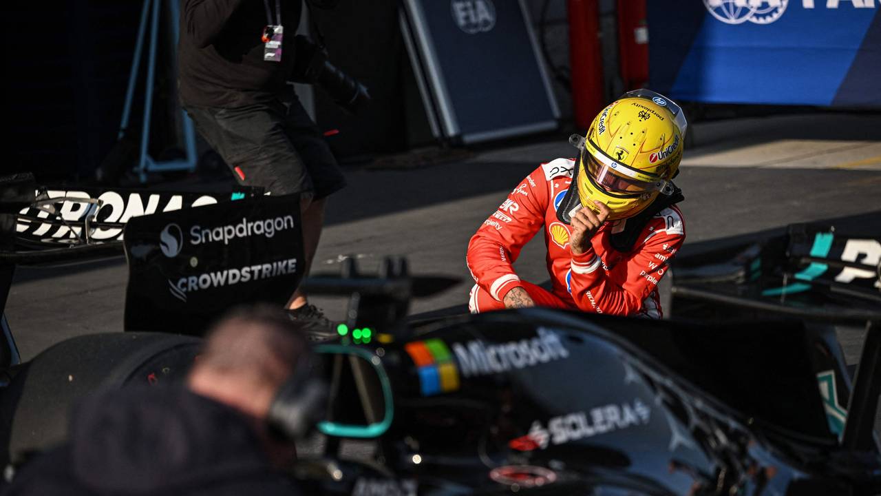 Lewis Hamilton schaut sich den Mercedes-Boliden in der Boxengasse aus der Nähe an.