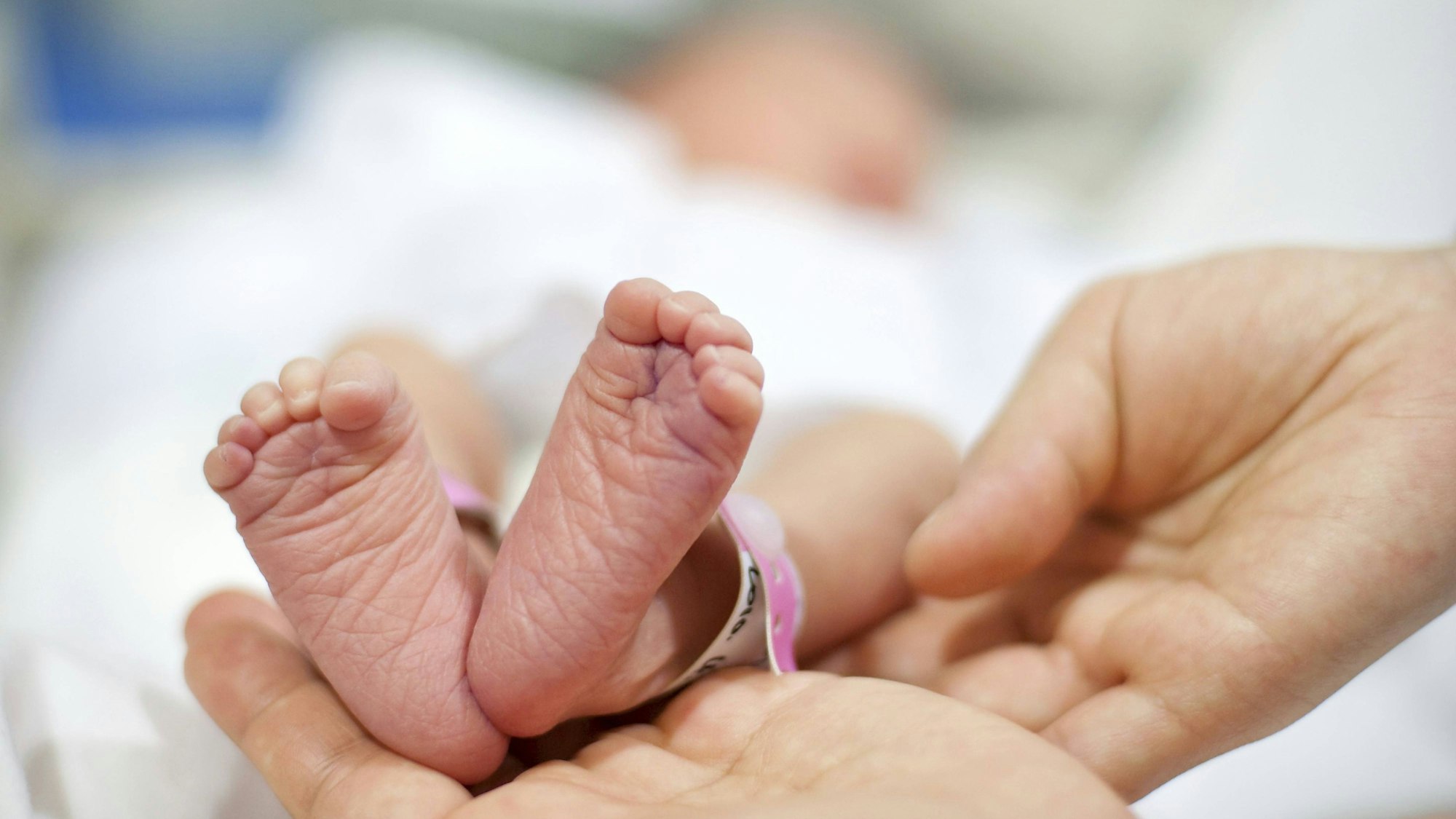 Vater hält Babyfüße des Neugeborenen