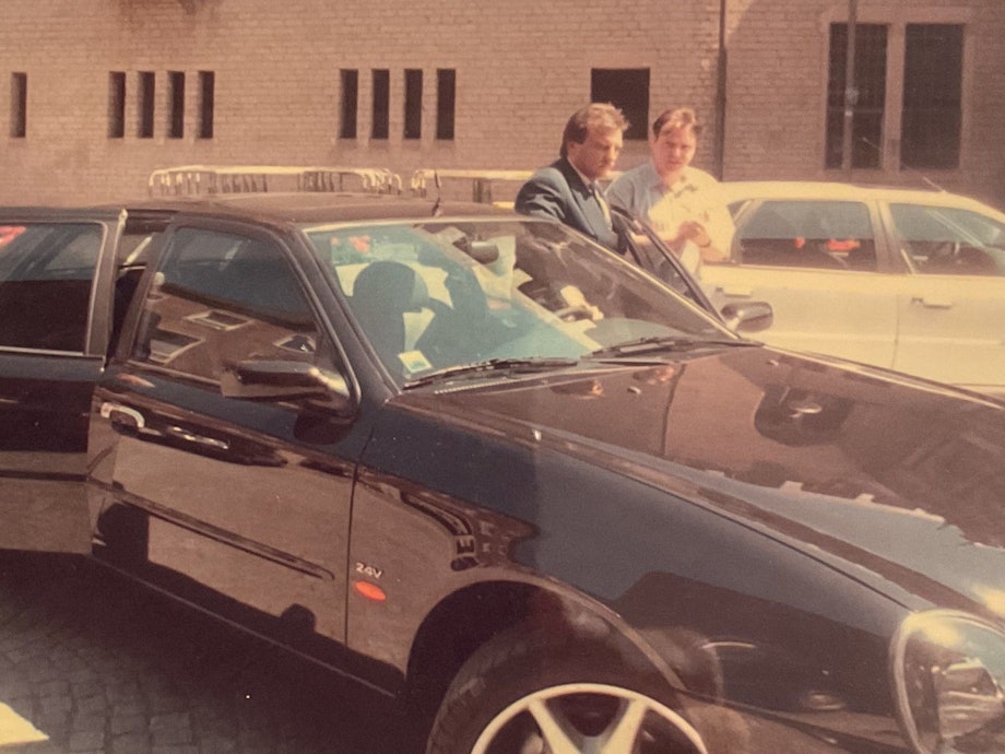 Zeitzeugen-Dokument: Erwin Müller steigt in den Dienstwagen, während der Kölner Oberbürgermeister Norbert Burger (l.) die Fahrzeugtür öffnet. Müller war von 1991 bis 1999 Burgers Cheffahrer.