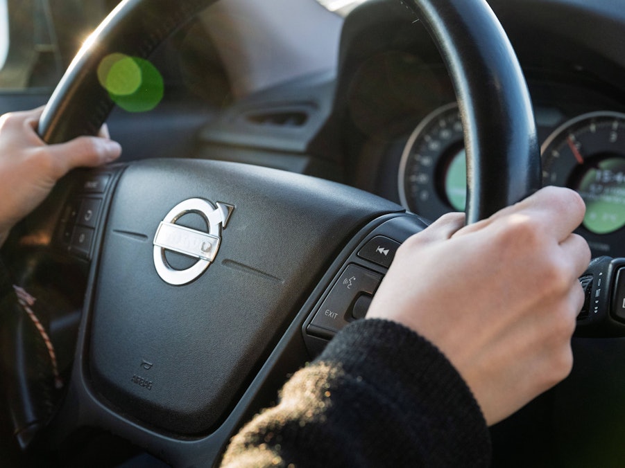 Hände am Lenkrad, Armaturen im Hintergrund