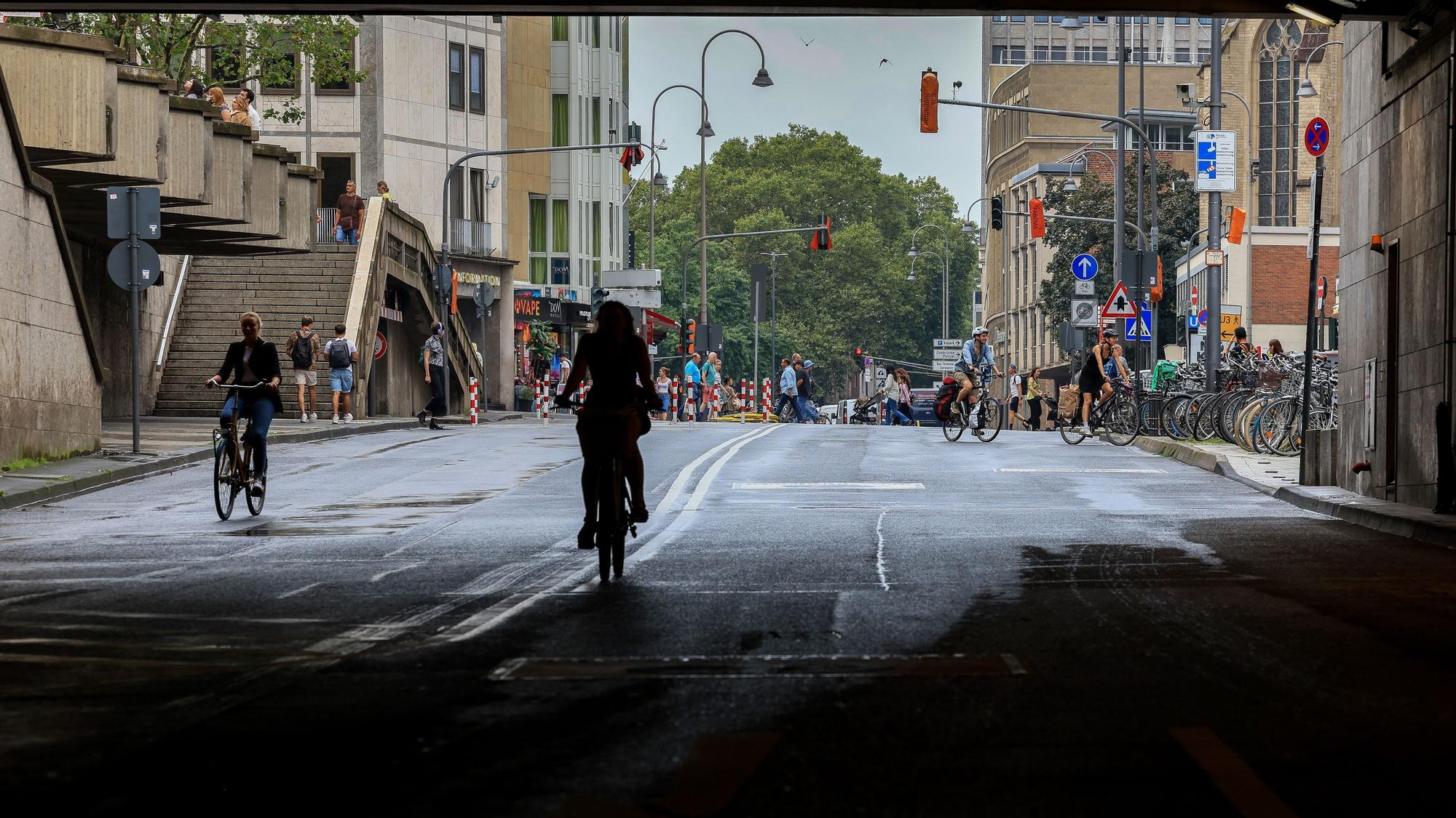Fahrradfahrer fahren auf der Trankgasse vor dem Kölner Dom