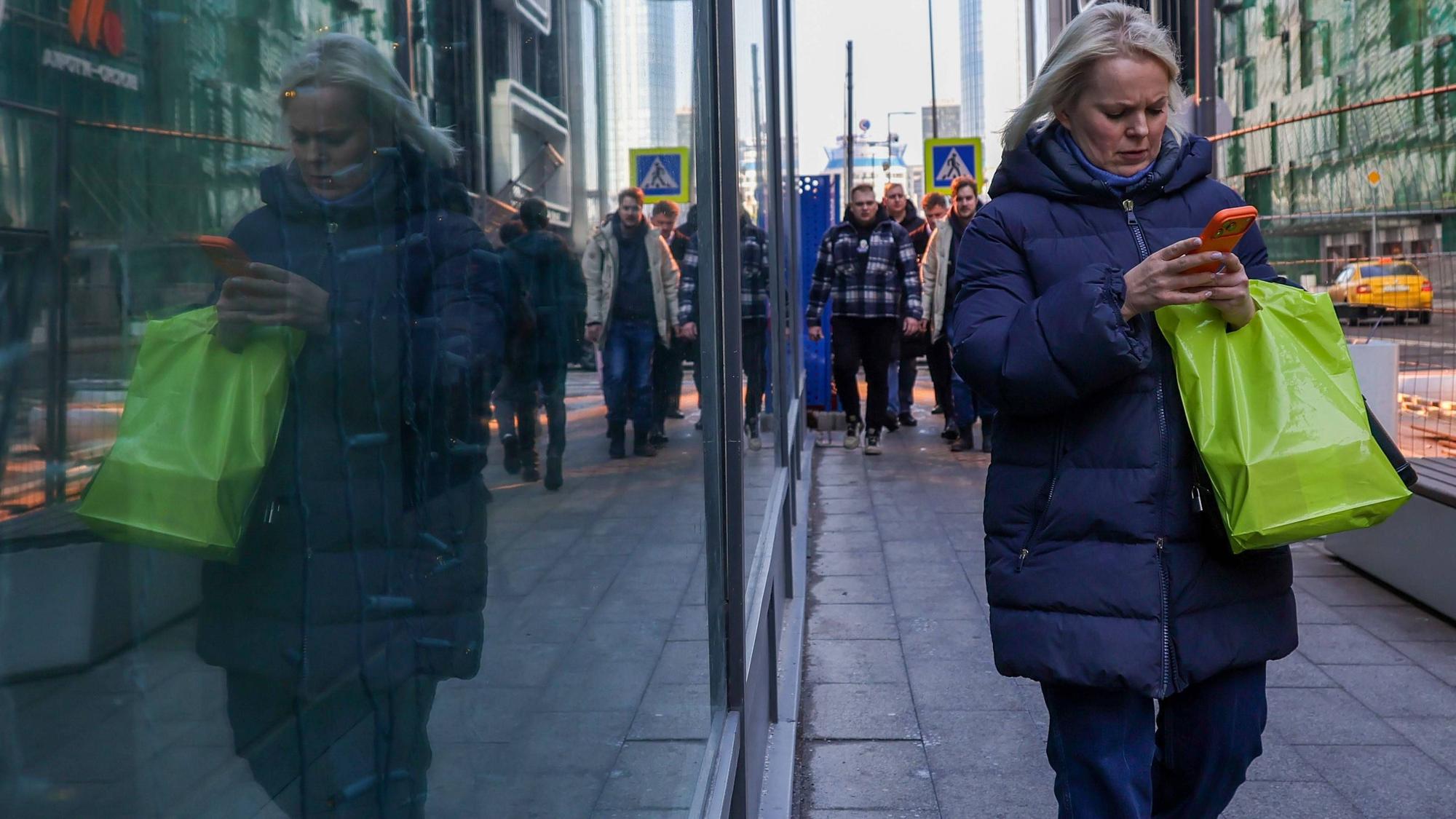 Eine Frau läuft mit ihrem Handy durch Moskau: In vielen russischen Großstädten gab es Probleme mit dem Mobilfunk.