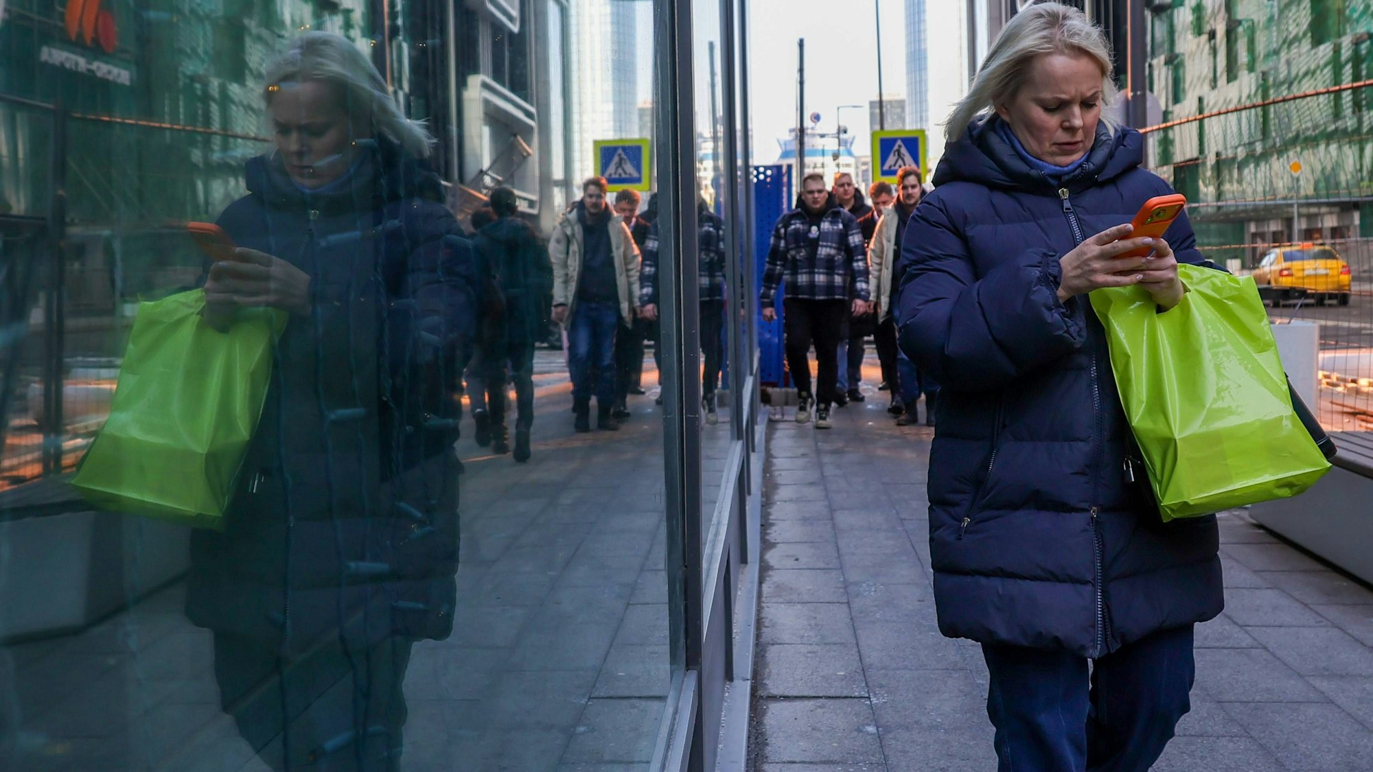 Eine Frau läuft mit ihrem Handy durch Moskau: In vielen russischen Großstädten gab es Probleme mit dem Mobilfunk.