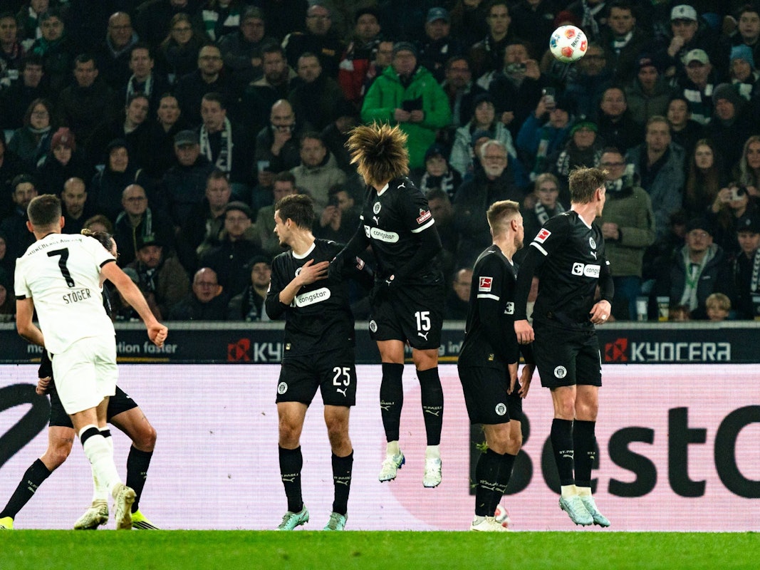 Kevin Stöger sowie zahlreiche Spiele des FC St. Pauli schauen dem Ball hinterher.
