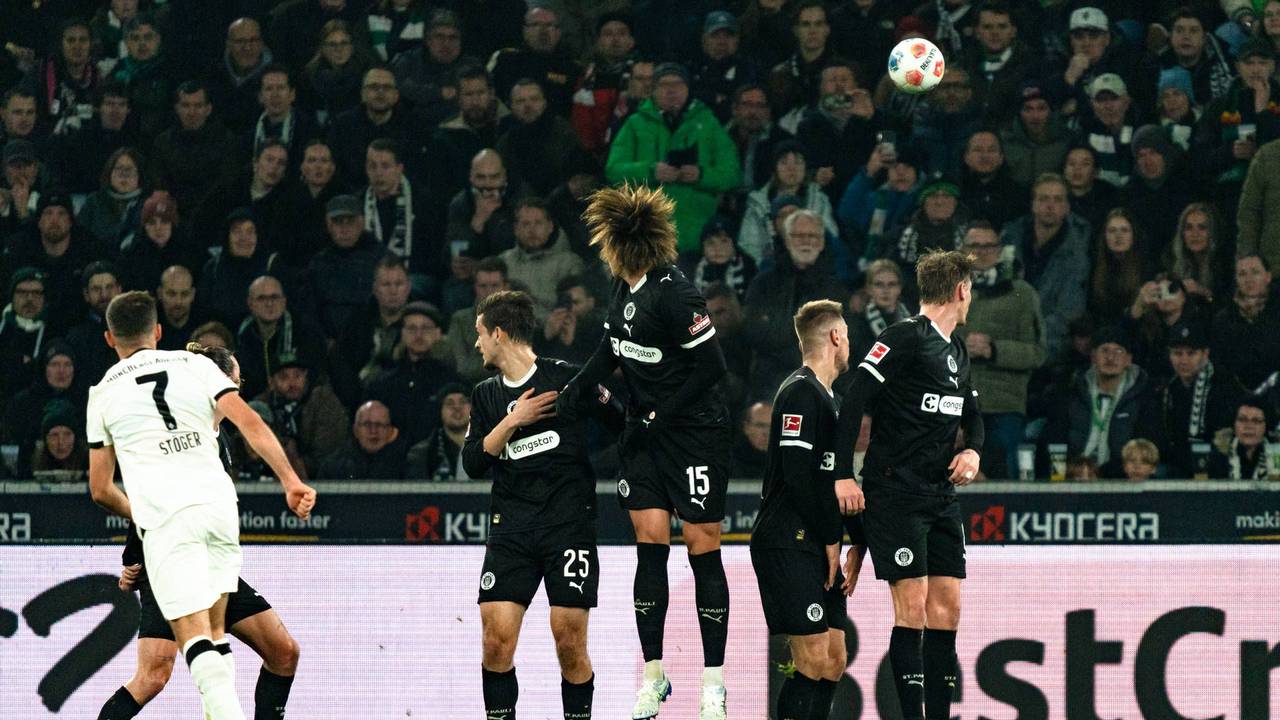 Kevin Stöger sowie zahlreiche Spiele des FC St. Pauli schauen dem Ball hinterher.