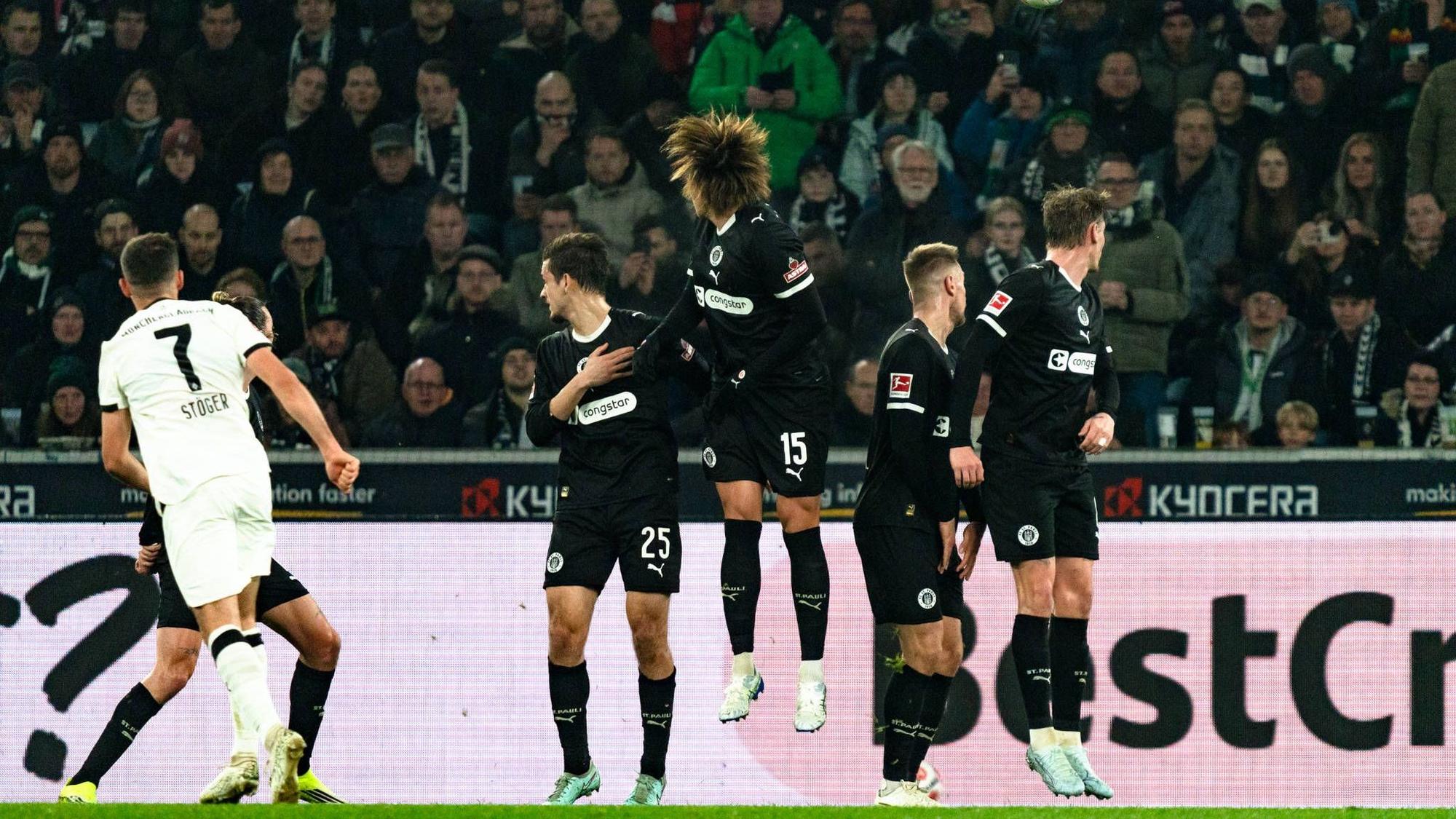 Kevin Stöger sowie zahlreiche Spiele des FC St. Pauli schauen dem Ball hinterher.