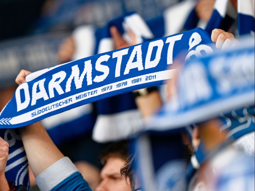 Darmstadts Fans halten ihre Schals in die Höhe.