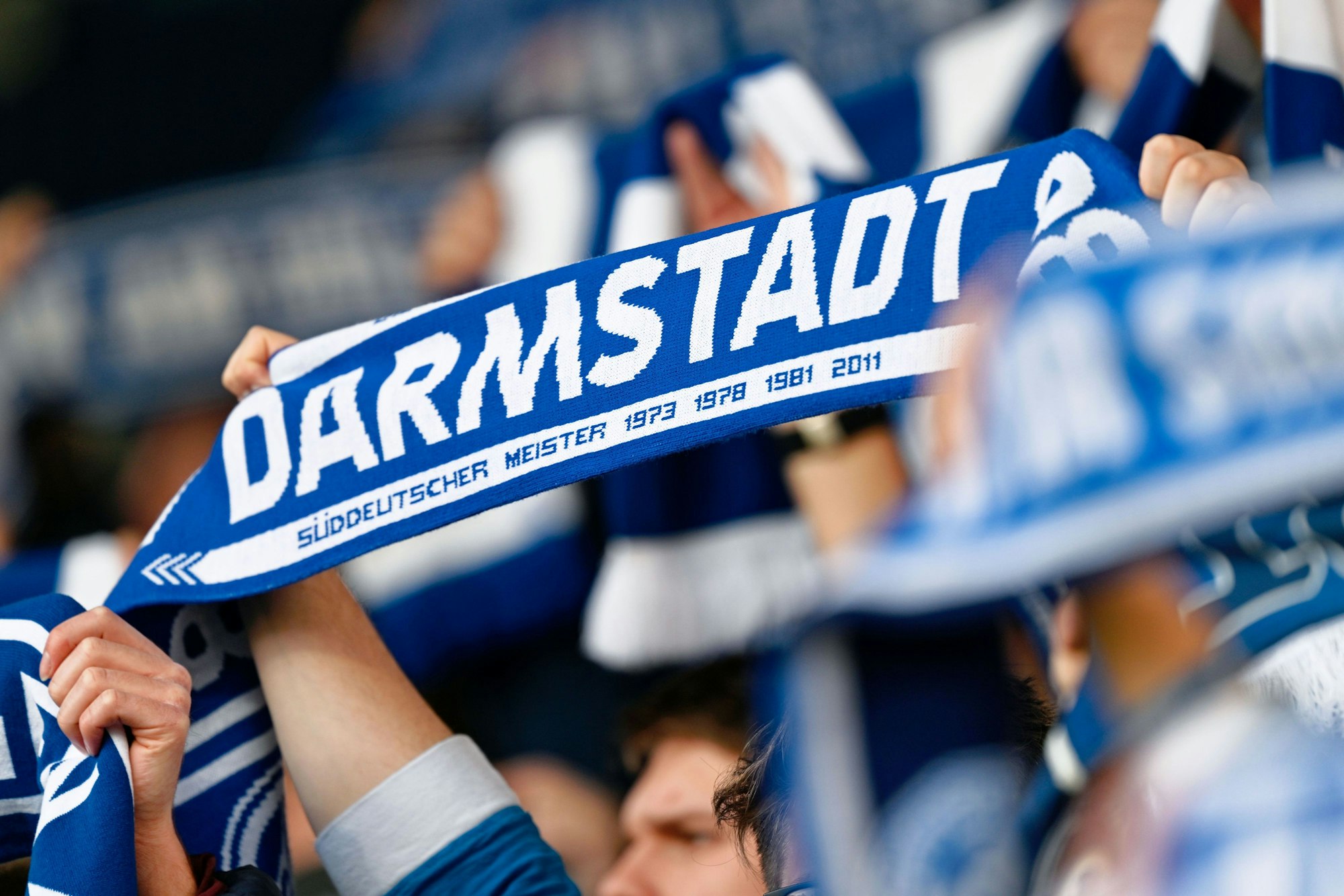 Darmstadts Fans halten ihre Schals in die Höhe.