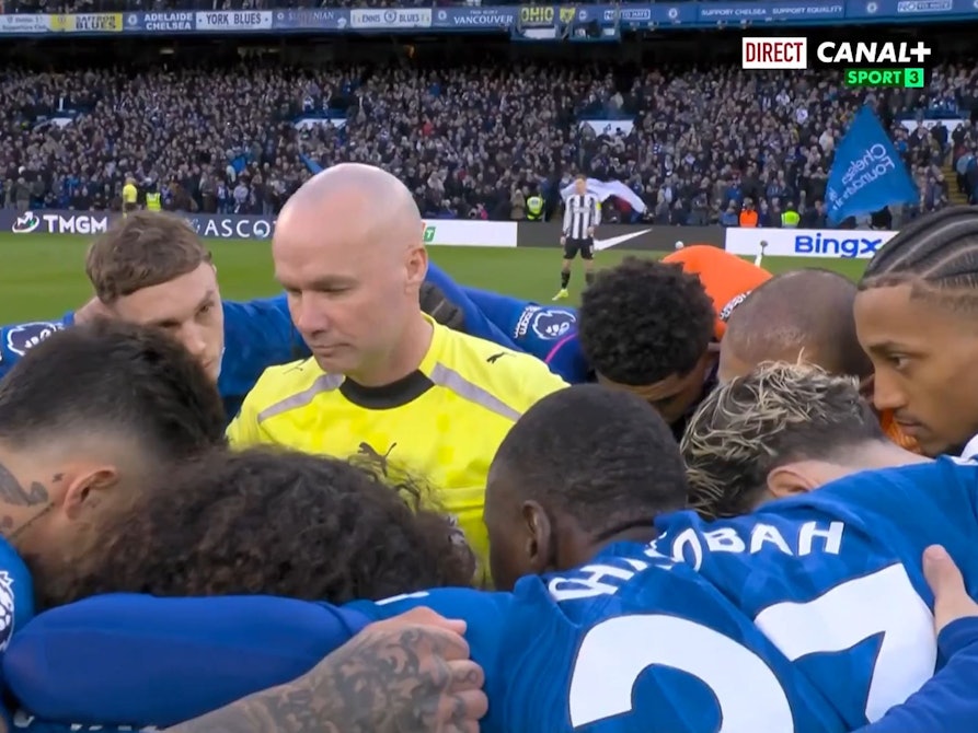 Schiedsrichter Paul Tierney inmitten des Spielerkreises des FC Chelsea.