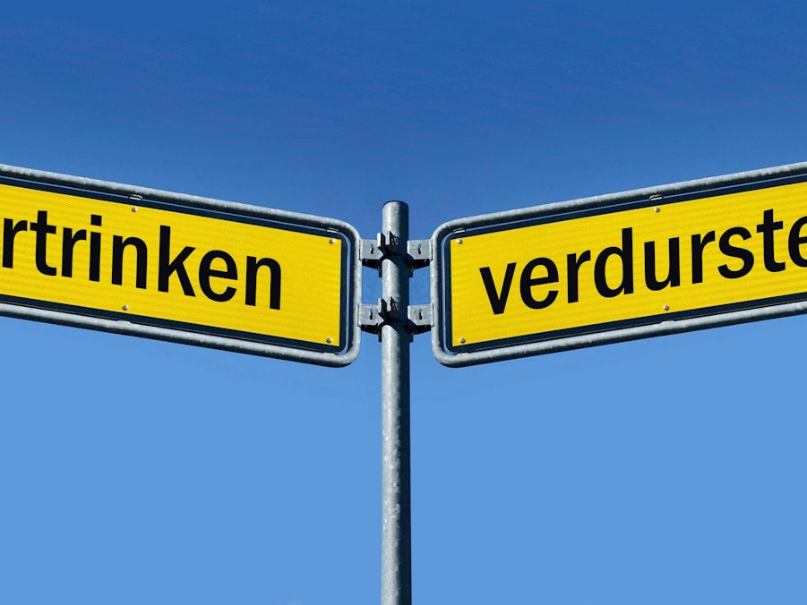 Zwei Wegweiser mit „ertrinken“ und „verdursten“