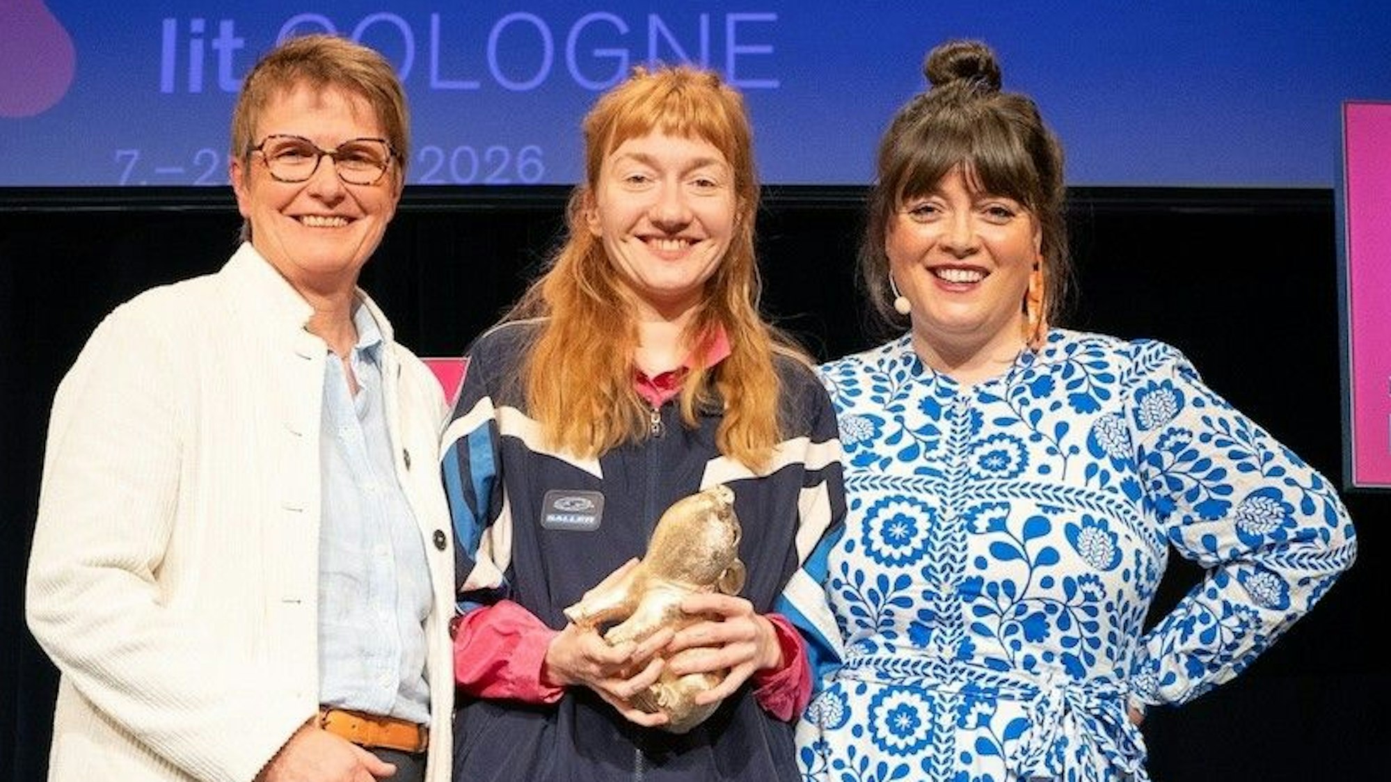 Bei der lit.COLOGNE-Debütpreis-Verleihung am Sonntagabend fiel die Wahl des Publikums auf Clara Leinemann (Mitte). Birgit Lichtenstein, Vorständin der RheinEnergie AG (li.), überreichte der glücklichen Gewinnerin das beliebte „Silberschwein“. Durch den Abend führte Moderatorin Marie-Christine Knop.