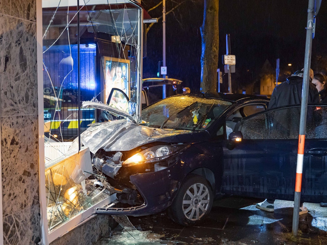 13.03.2026, Nordrhein-Westfalen, Leverkusen: Ermittler stehen an der Unfallstelle, wo ein Fahrer mit seinem Auto in ein Schaufenster gekracht ist. Ein Mann hat sein Auto in Leverkusen in die Schaufensterscheibe einer Bäckerei gefahren und dabei leichte Verletzungen erlitten. Foto: Daniel Evers/WupperVideo/dpa +++ dpa-Bildfunk +++
