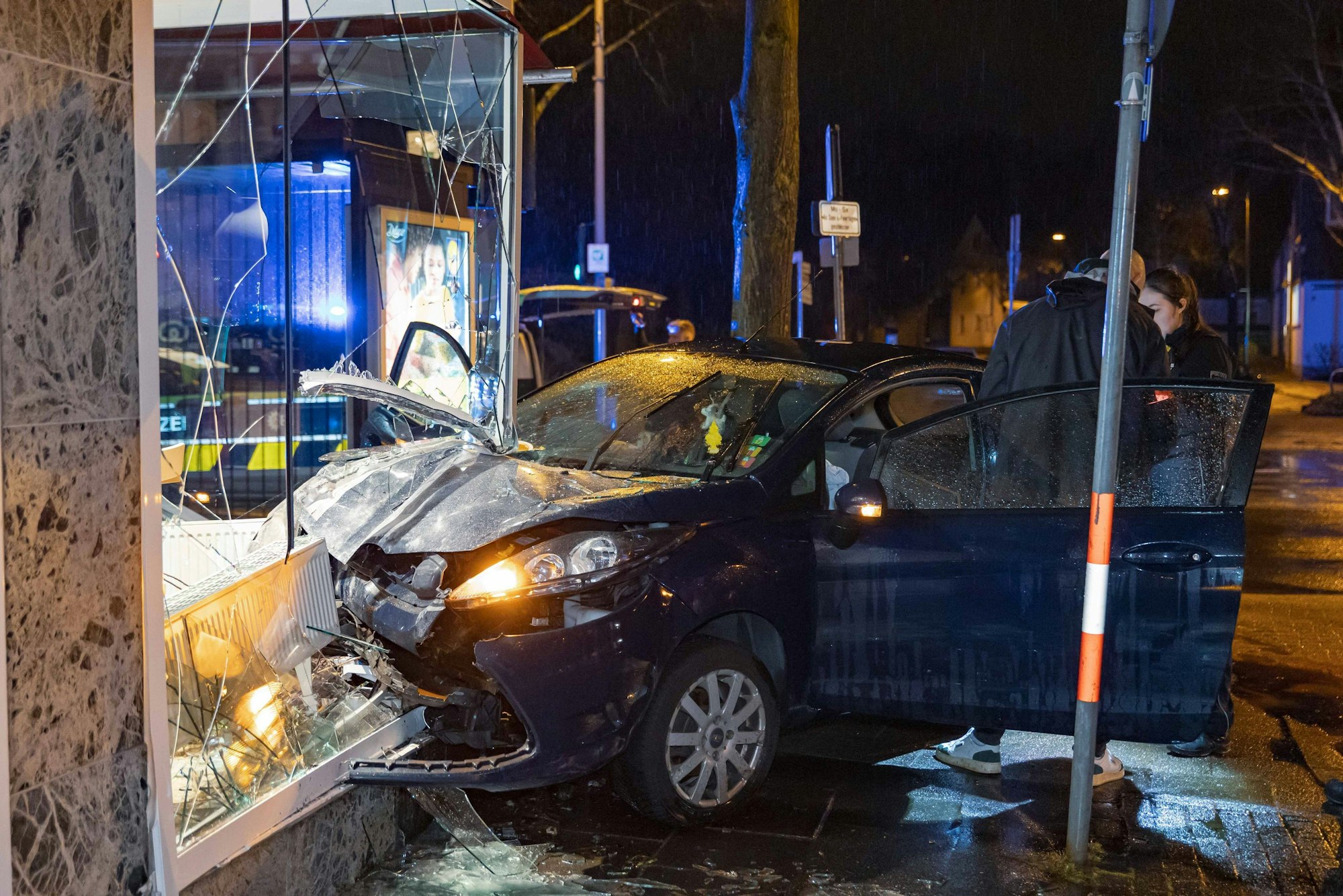 13.03.2026, Nordrhein-Westfalen, Leverkusen: Ermittler stehen an der Unfallstelle, wo ein Fahrer mit seinem Auto in ein Schaufenster gekracht ist. Ein Mann hat sein Auto in Leverkusen in die Schaufensterscheibe einer Bäckerei gefahren und dabei leichte Verletzungen erlitten. Foto: Daniel Evers/WupperVideo/dpa +++ dpa-Bildfunk +++