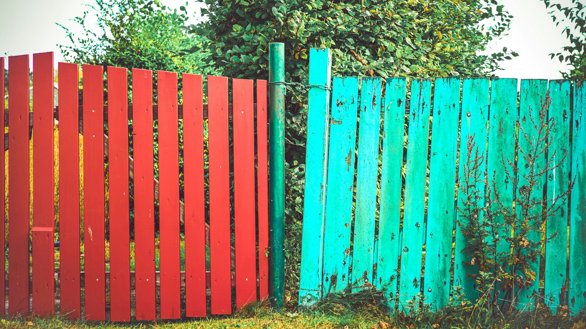 Zwei bunte Zäune, Symbolbild Nachbarschaftsstreit