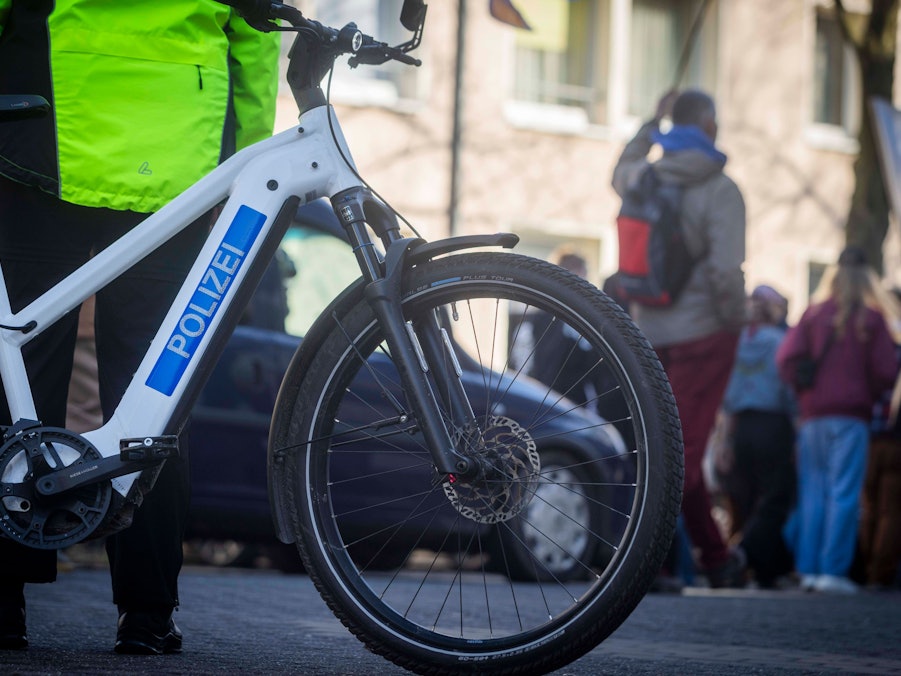 Polizistin mit Polizeifahrrad und Passanten