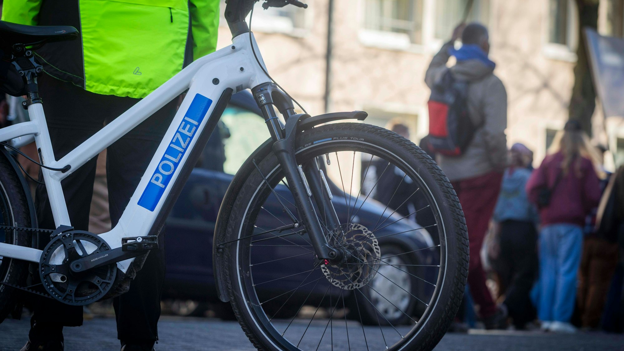 Polizistin mit Polizeifahrrad und Passanten