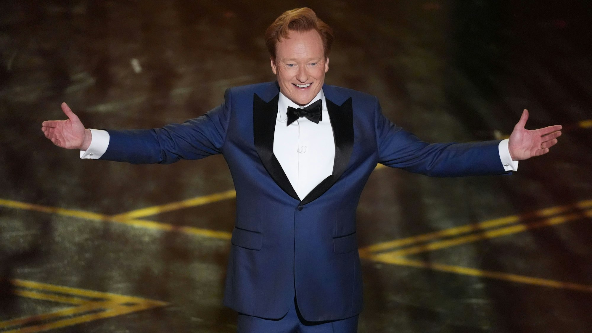 Moderator Conan O'Brien breitet die Amre aus.