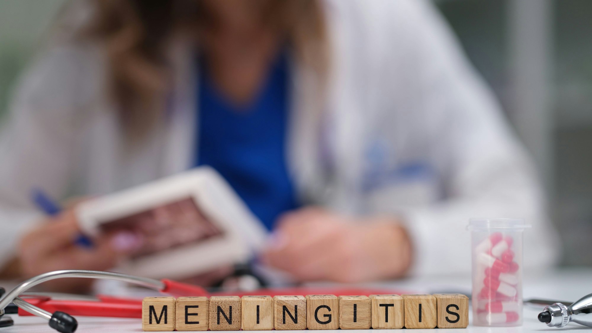 Medizinische Fachkraft und Schriftzug Meningitis