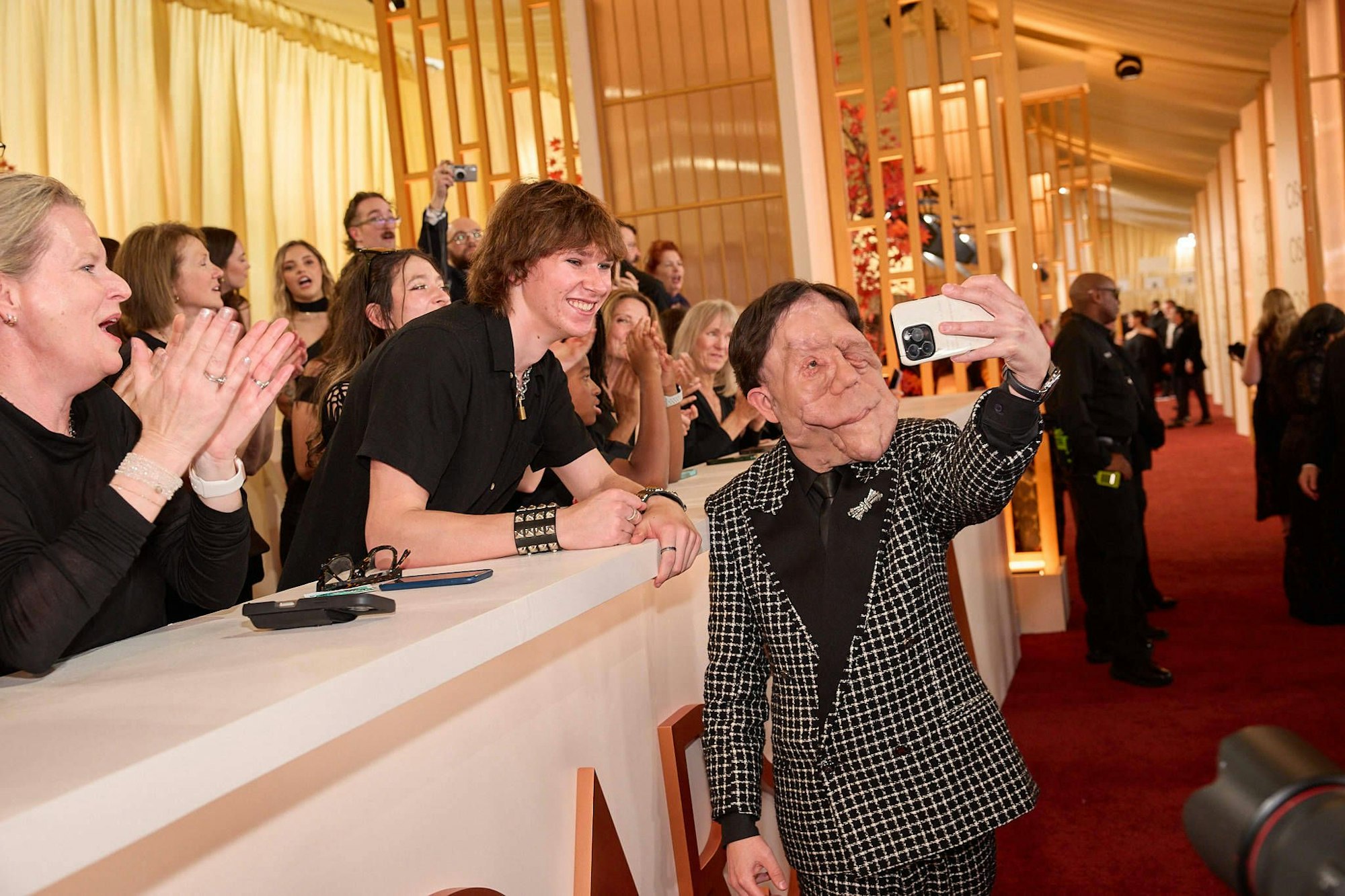 Adam Pearson lässt sich auf dem roten Teppich feiern und macht einige Selfies mit den Fans.