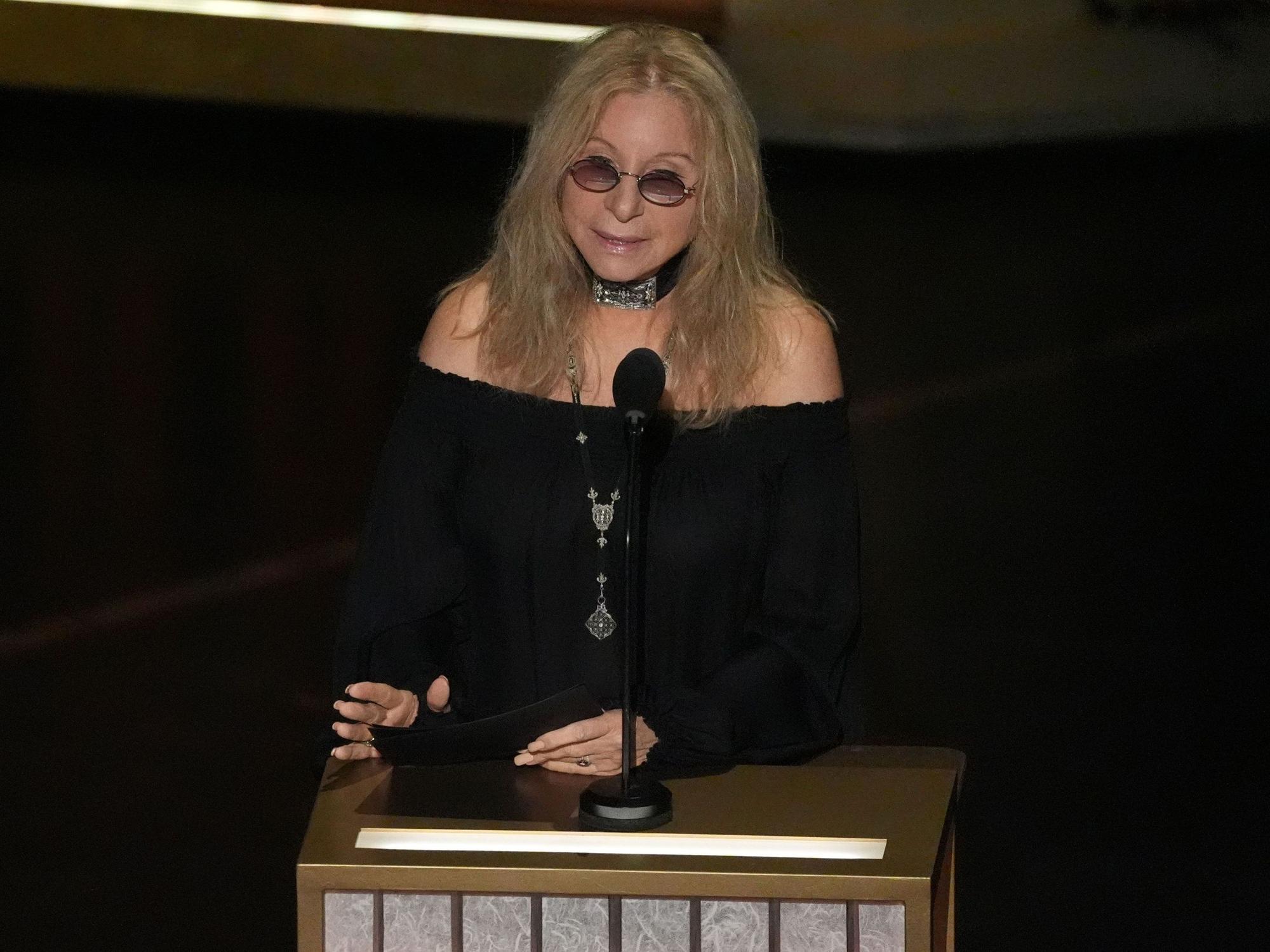 Barbra Streisand spricht in ein Mikrofon.