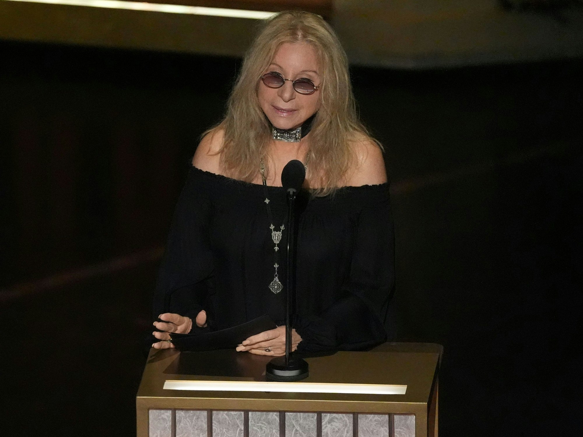 Barbra Streisand spricht in ein Mikrofon.