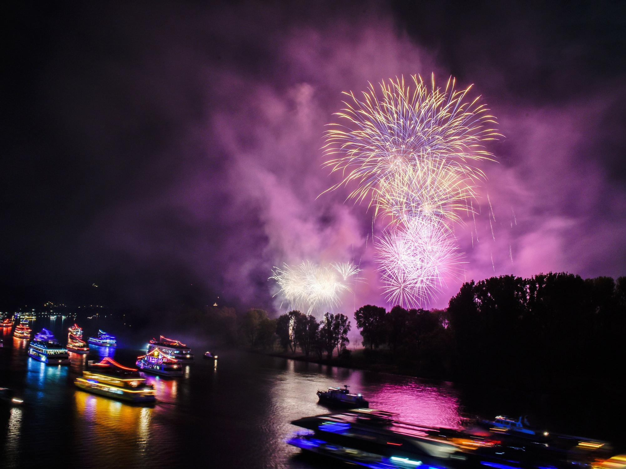 Bunt beleuchtete Boote und Schiffe sowie ein Feuerwerk sind in Bonn zu sehen.