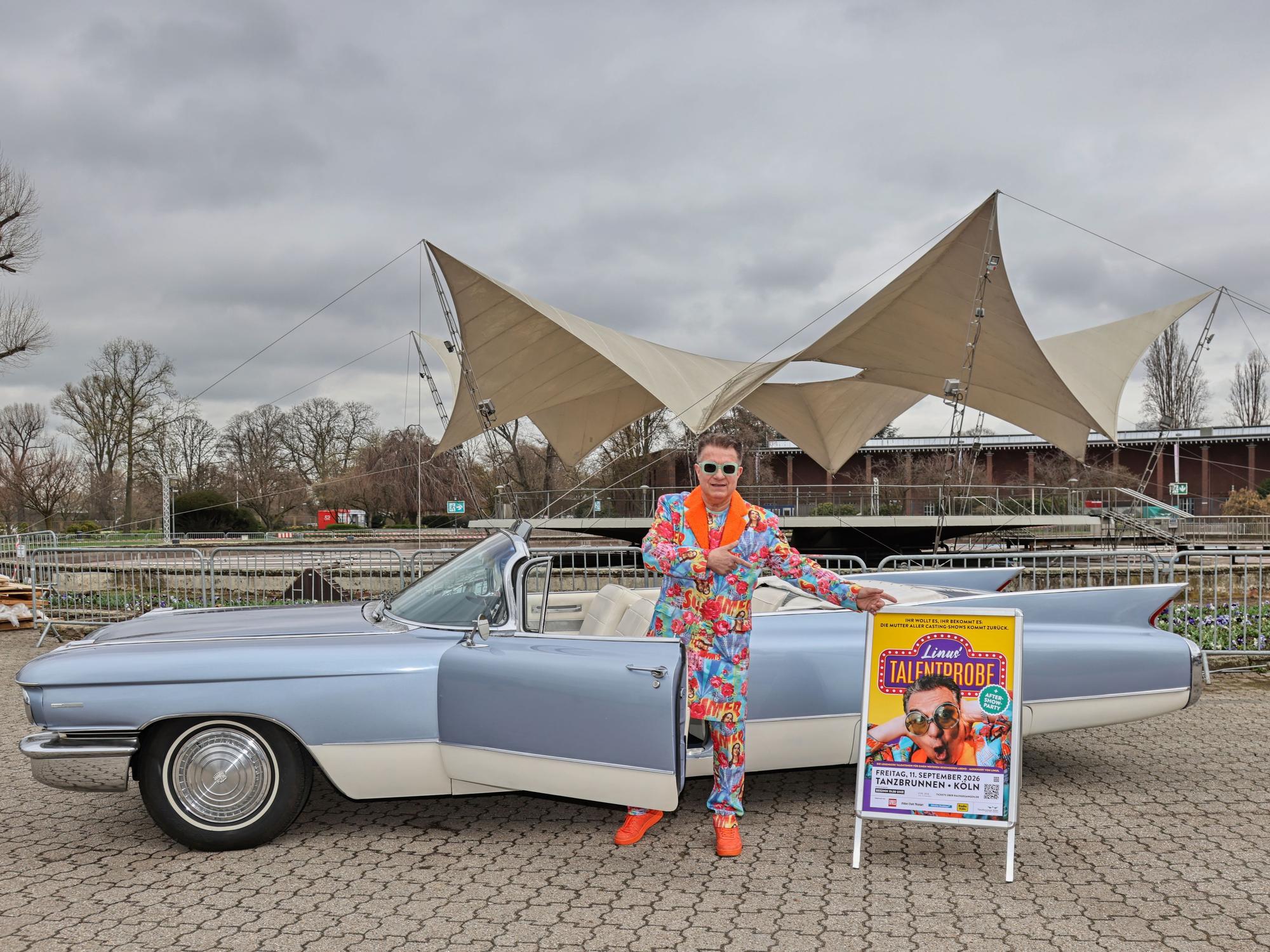 Linus steht vor einem Cadillac im Tanzbrunnen.