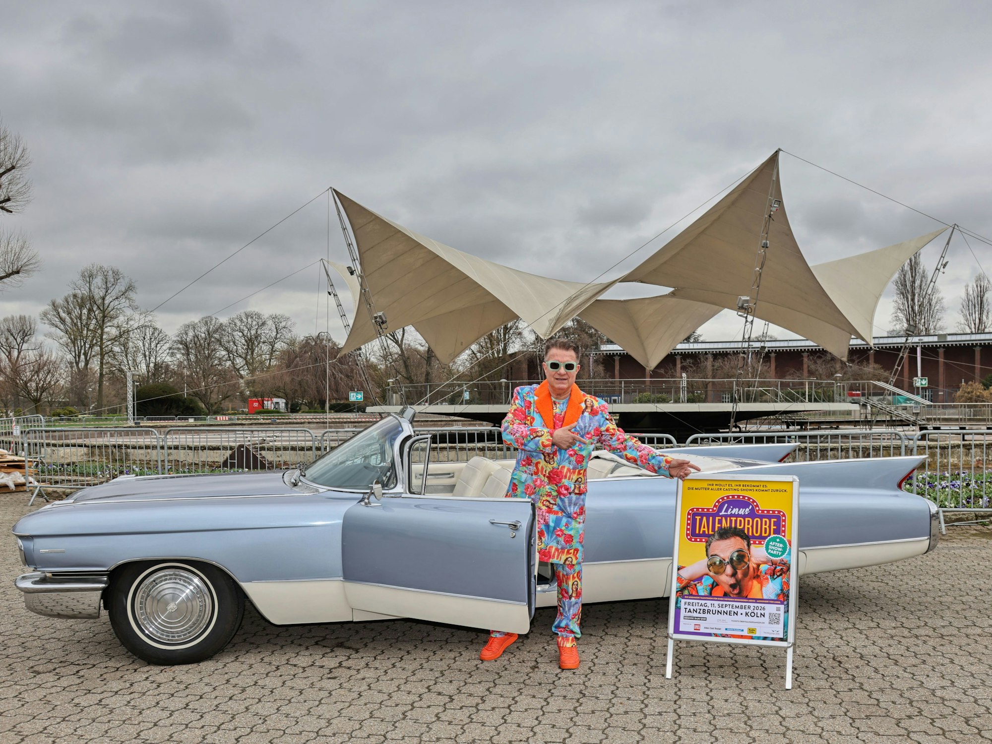 Linus steht vor einem Cadillac im Tanzbrunnen.