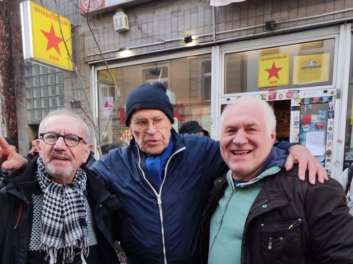 Drei Männer stehen vor einem Kiosk.