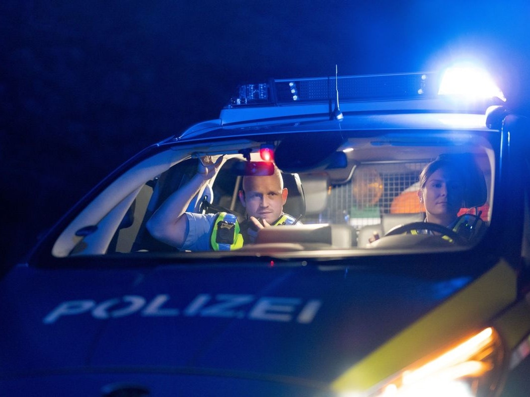 Ein Taxi steht nachts an einer Straße.