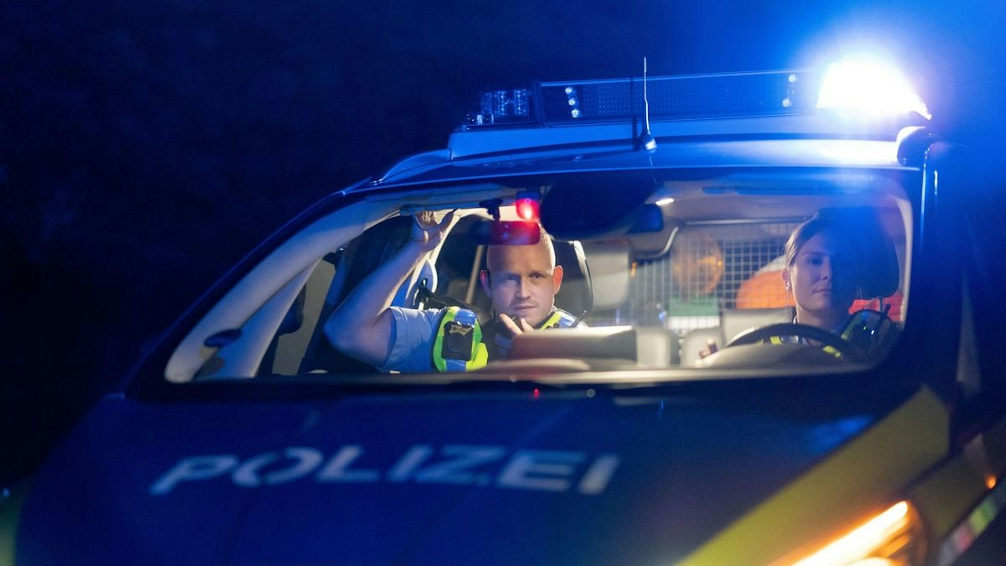 Ein Taxi steht nachts an einer Straße.