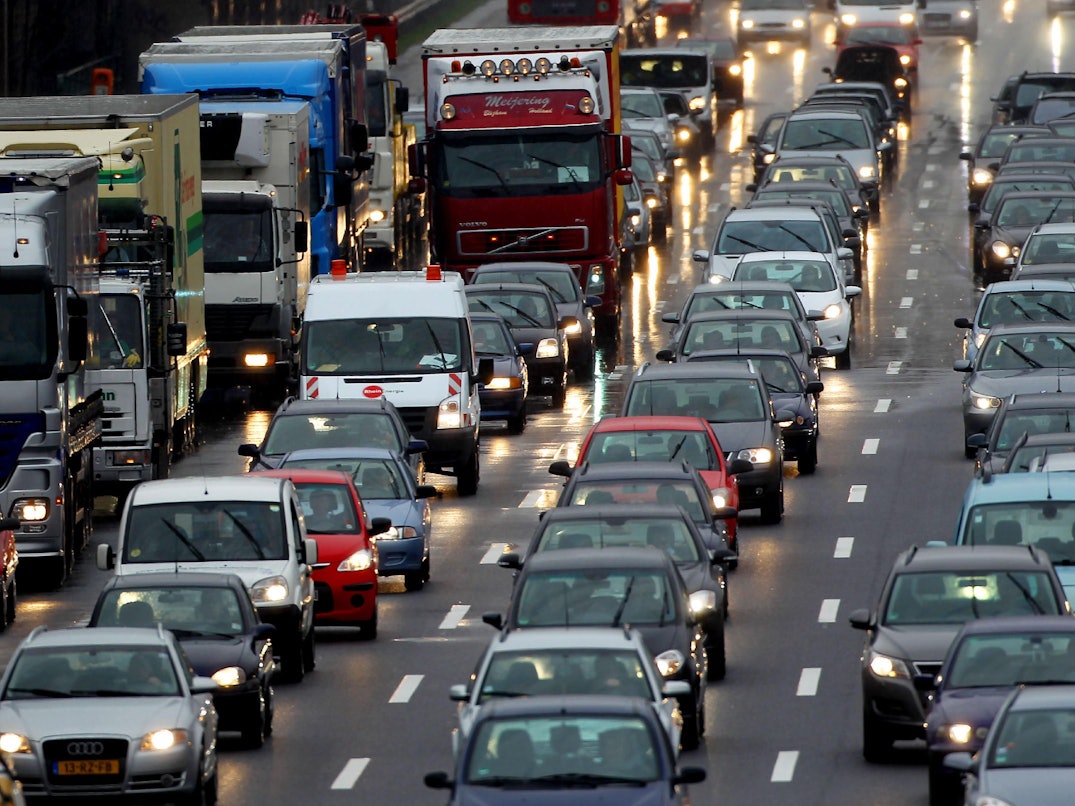 Autos und Lkws stauen sich auf einer vierspurigen Straße.