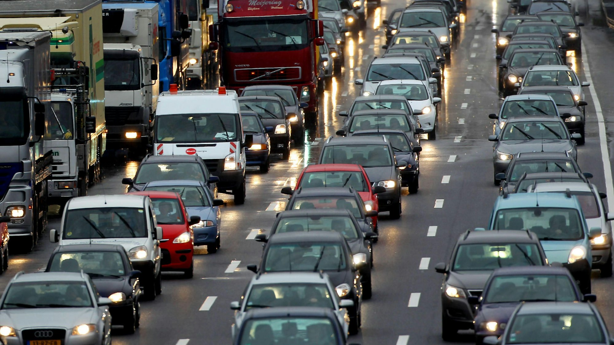 Autos und Lkws stauen sich auf einer vierspurigen Straße.