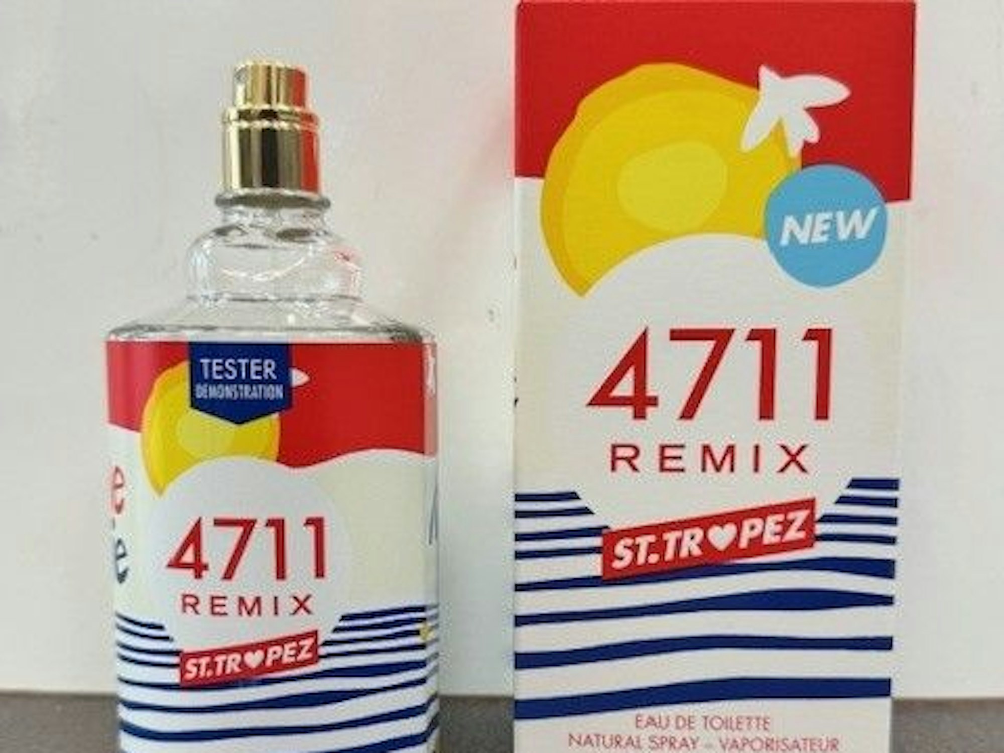 Ein bunter Parfumflakon mit ebensolchem Karton