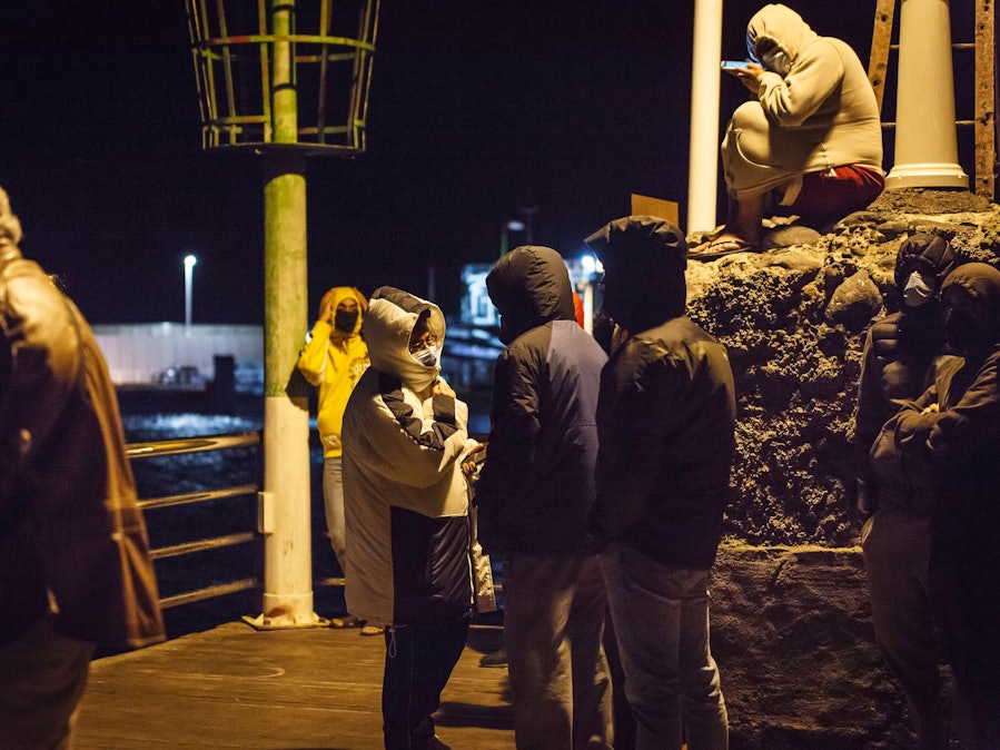 Mehrere Personen auf einem Steg bei Nacht