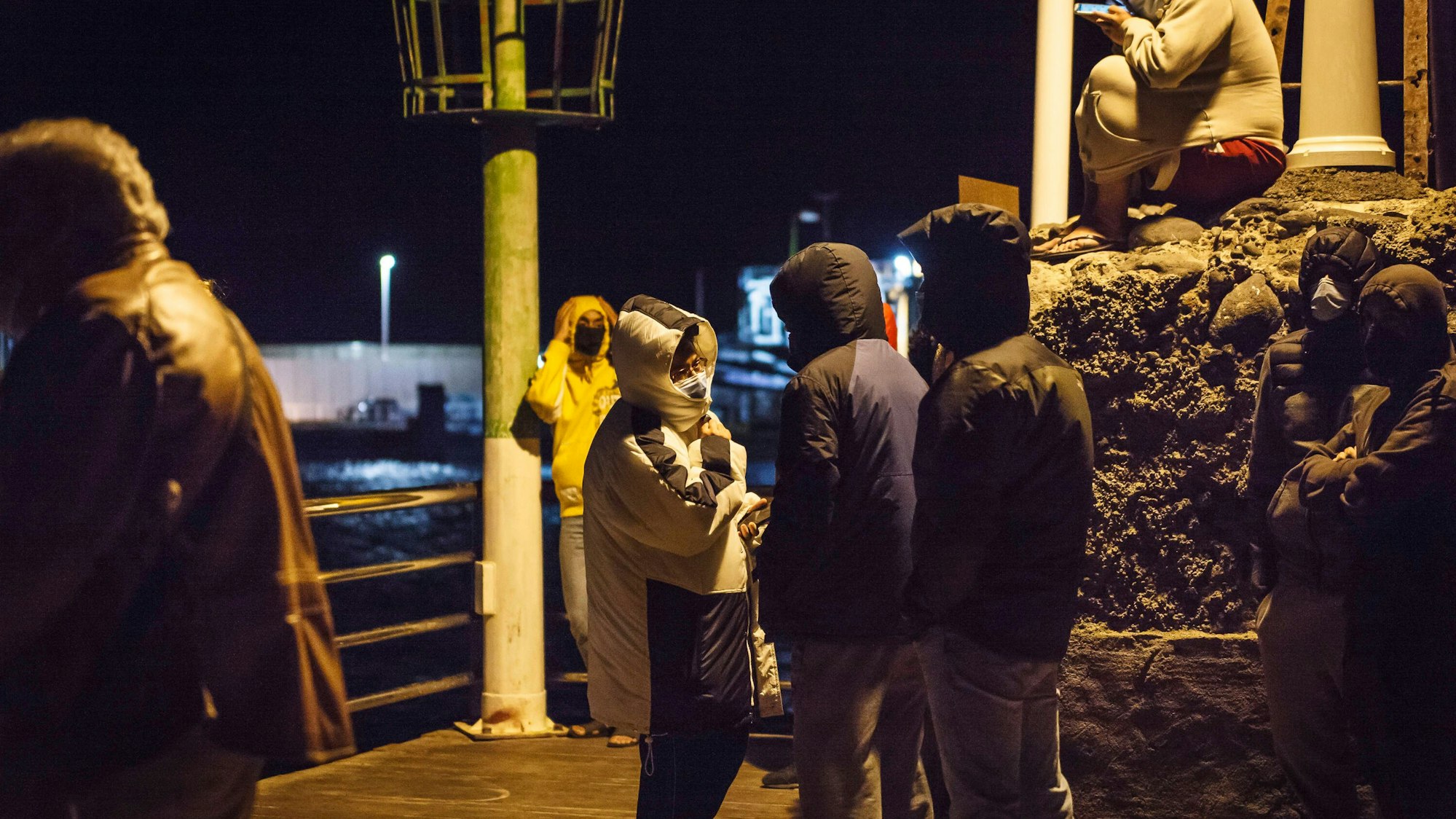 Mehrere Personen auf einem Steg bei Nacht