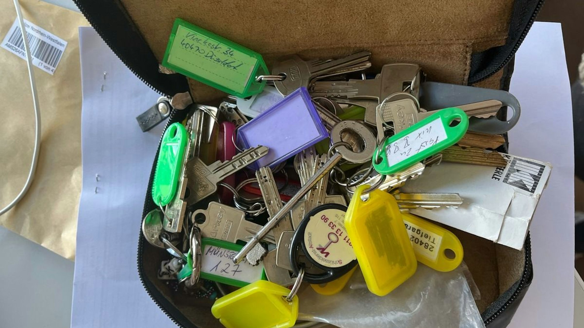 Sichergestelltes Diebesgut: eine beige Sonnenbrille, eine graue Daunenjacke und eine schwarze Ledertasche.