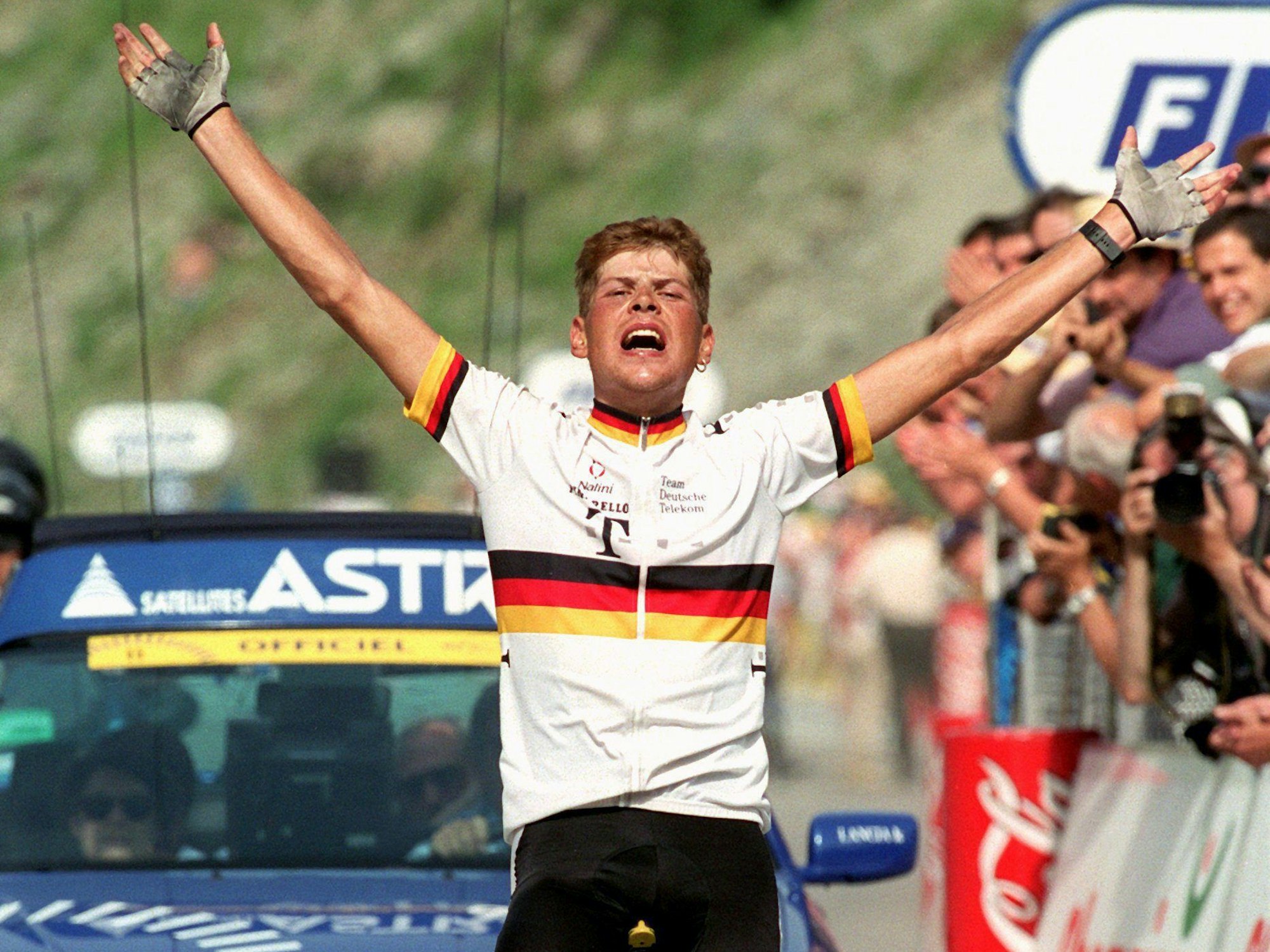 Jan Ullrich reißt beim Passieren des Zielstrichs jubelnd die Arme hoch.