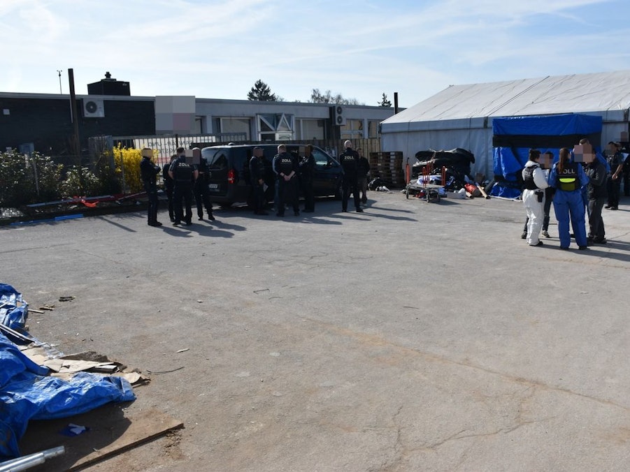 Zollbeamte bei einer Kontrolle in einer Halle.