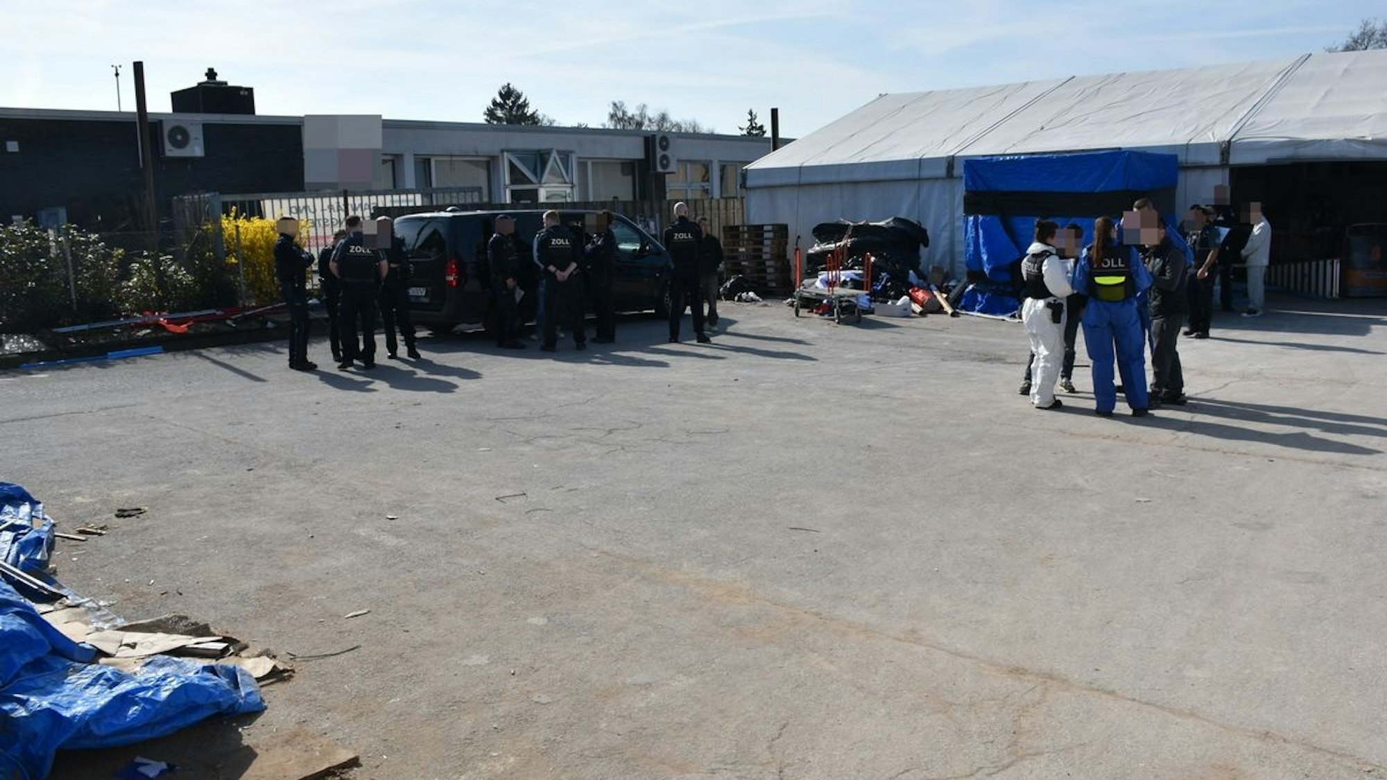 Zollbeamte bei einer Kontrolle in einer Halle.