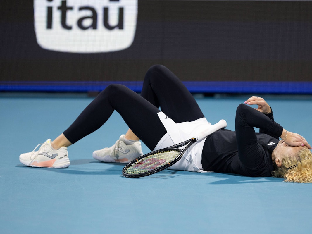 Katerina Siniakova liegt auf dem Rücken und hält sich eine Hand vors Gesicht.