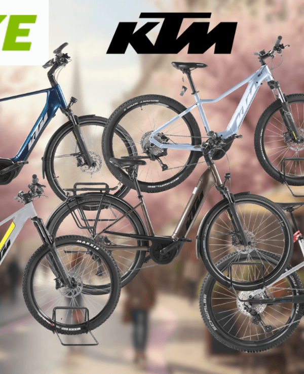 Mehrere KTM E-Bike Modelle vor einer sonnigen Innenstadt im Hintergrund.