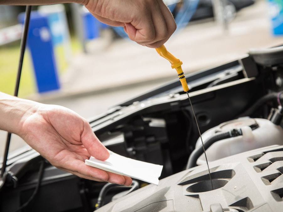 Ein Mann prüft den Ölstand seines Autos