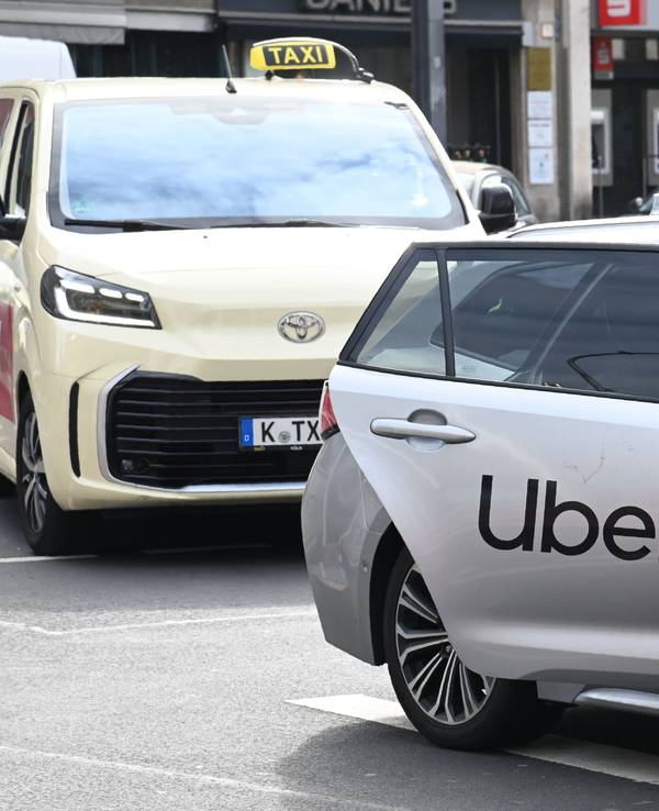 Ein Uber-Fahrzeug parkt vor einem Taxi mit Kölner Kennzeichen.